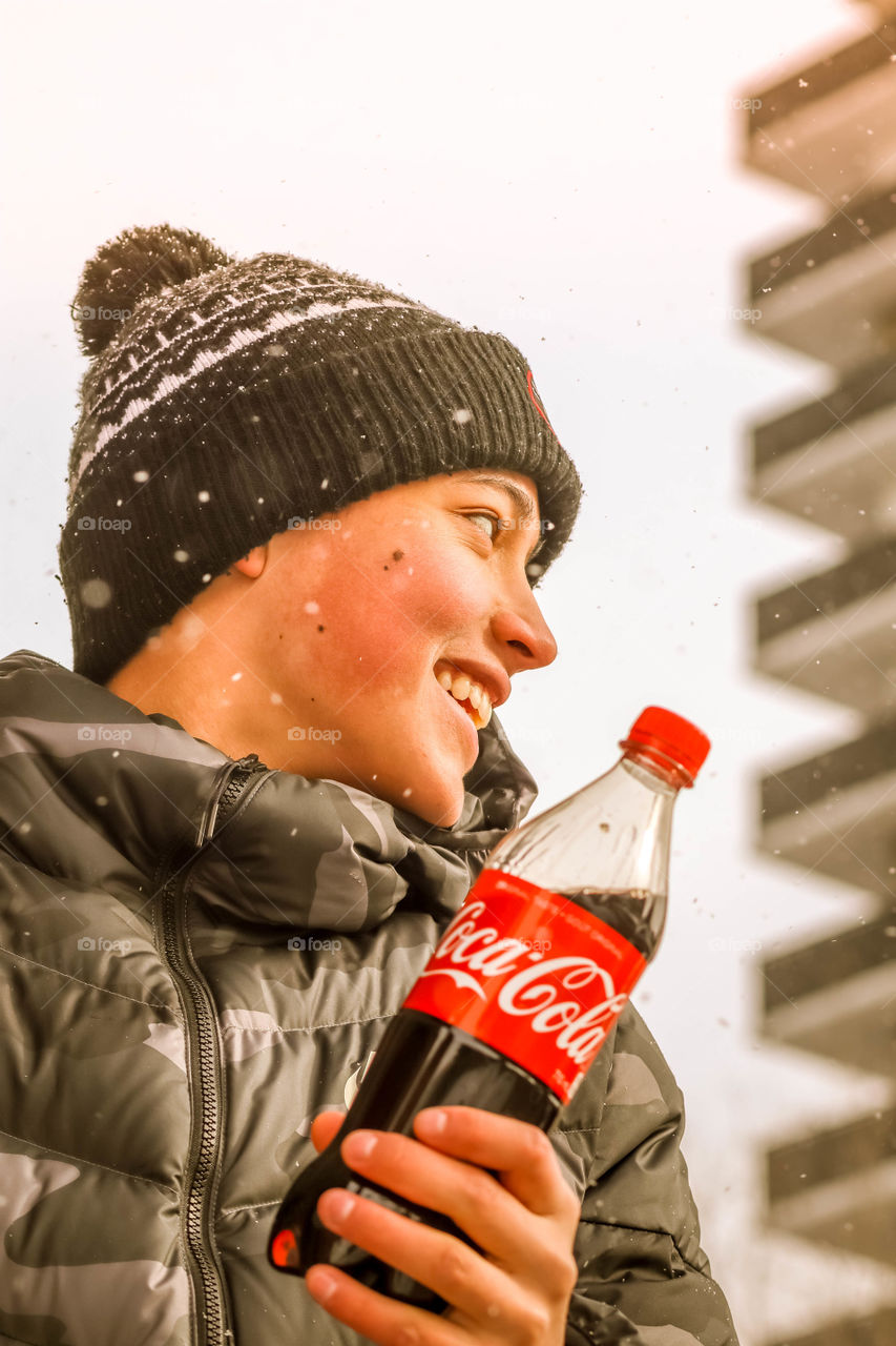 Happy teenager with a bottle of coca cola