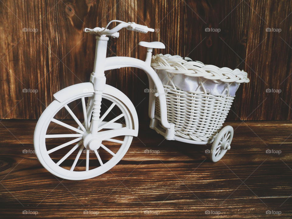 decorative children's bicycle on a dark background of boards