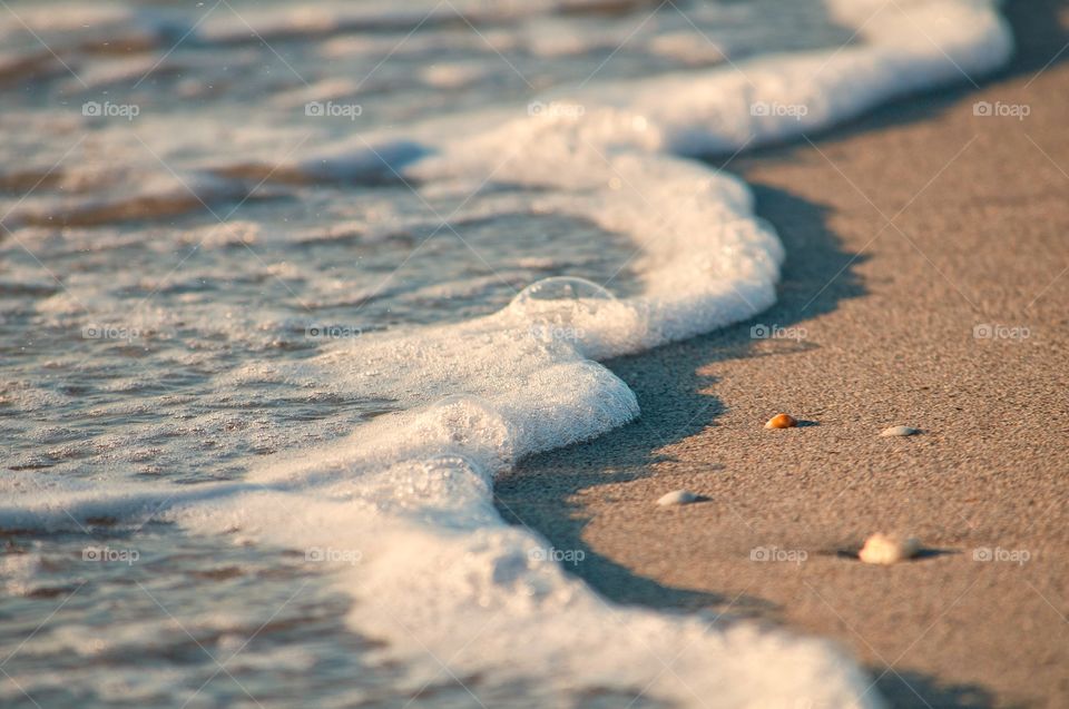 Waves roll on to the beach as the sun sets in Hollywood Beach, Florida. 