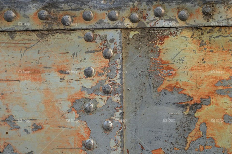 airplane fizulage seams of metal aluminum plates macro photo sheets are riveted with rivets into the overlay, the old method of metal welding, background, wallpaper