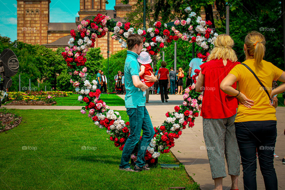 Father and daughter under the rose  arch