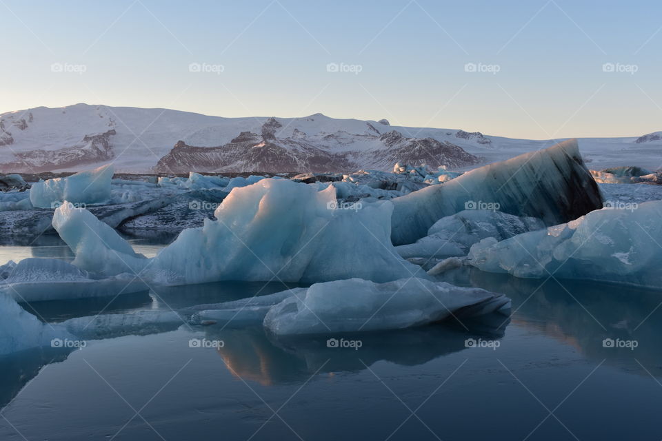 icebergs peacefully reflecting at sunset