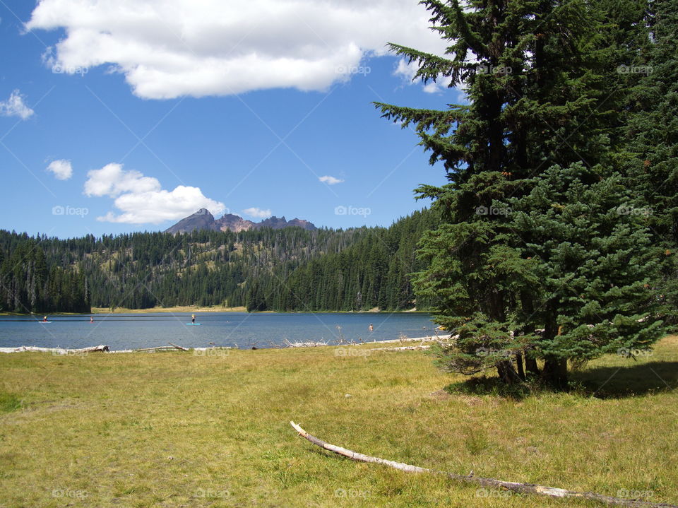 The grassy shores of Todd Lake with Broken Top in the background high up in Central Oregon’s Cascade Mountain Range on a sunny summer day. 