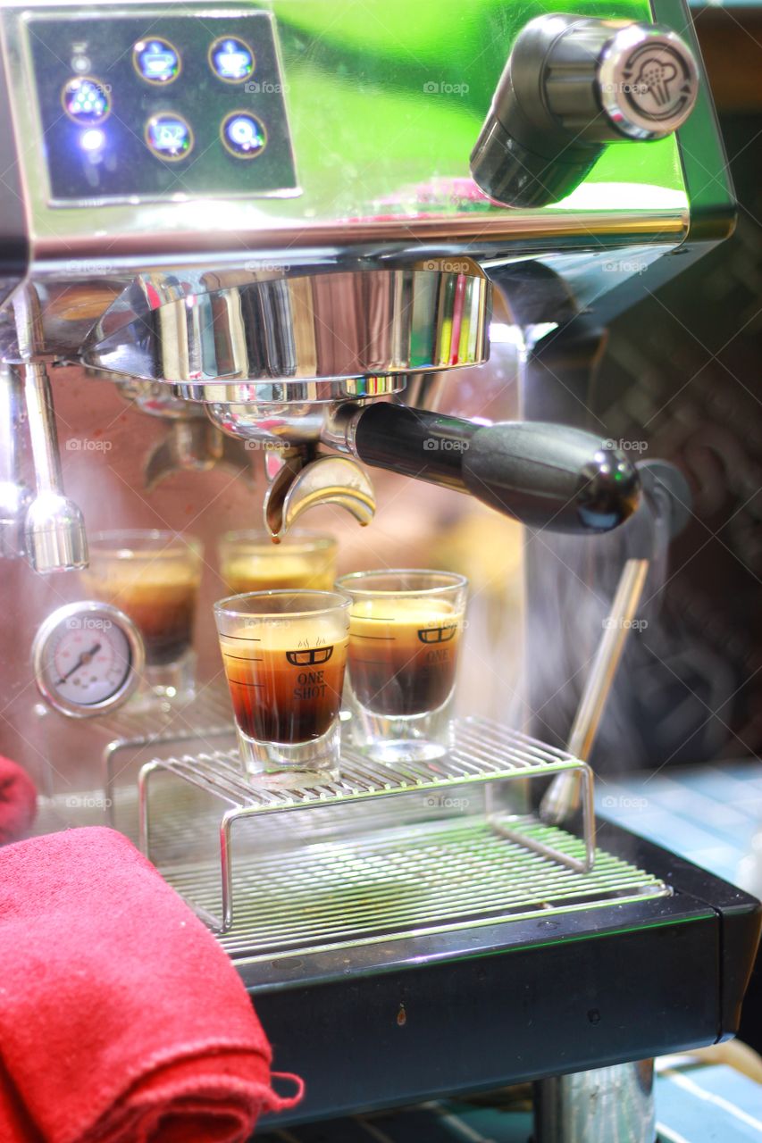 The freshly brewed coffee comes out of the coffee machine, the machine has 2 ways, 2 cups.