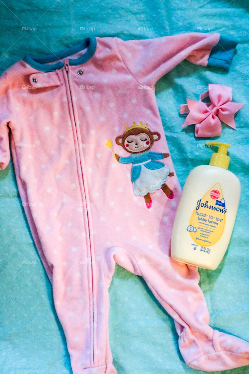 Johnson’s- pink onesie, a bow and Johnson’s Baby lotion.