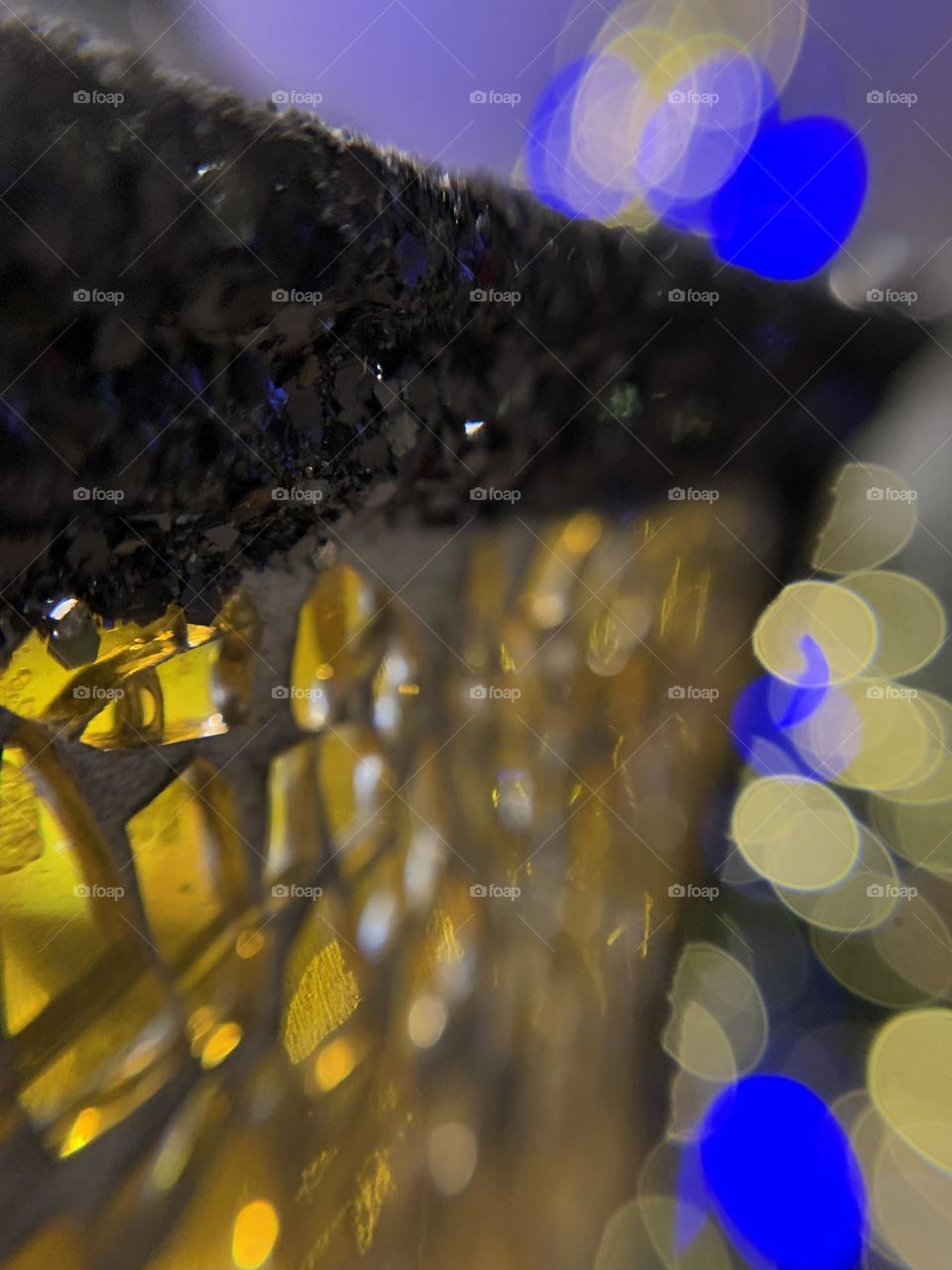 Macro lens fun. A Christmas night light that looks like an old street lamp. With crackled yellow glass, in front of the Christmas tree.