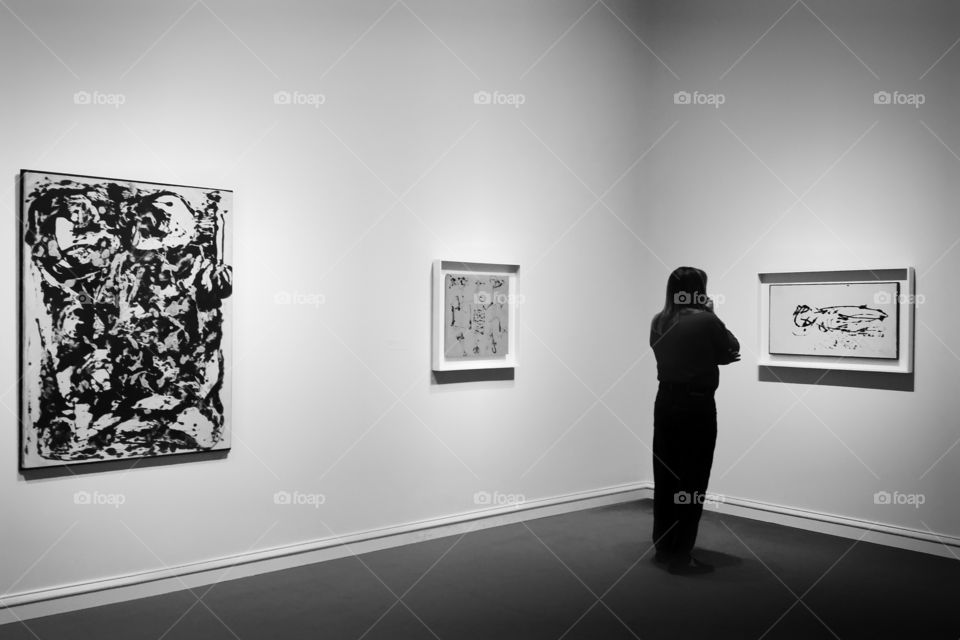 Woman in silhouette looking at art in black and white