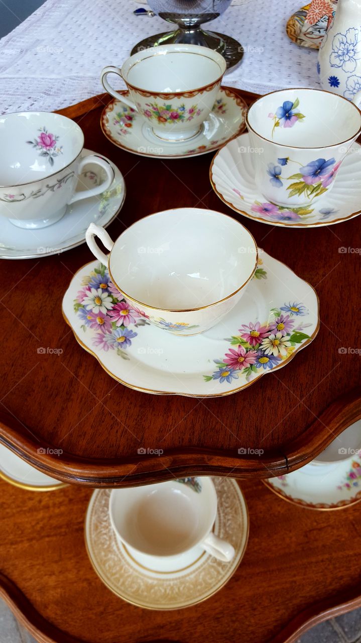 An array of antique tea cups sit waiting for guests to choose their favorite for a tea party.