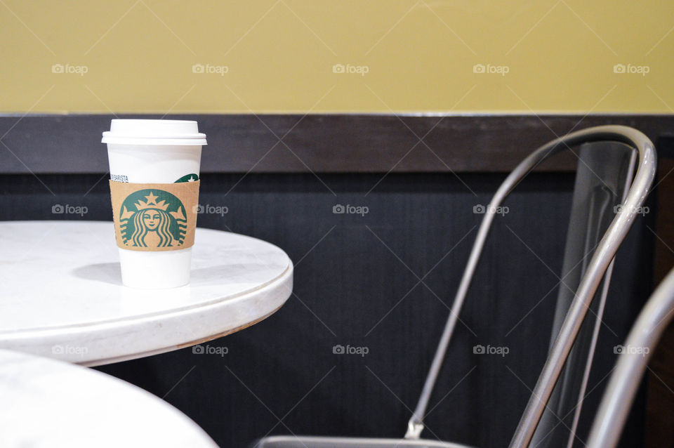 Starbucks coffee cup sitting on a white table at a Starbucks restaurant