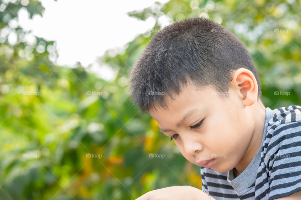 Portrait of Asian boys are playing mobile phones in park.