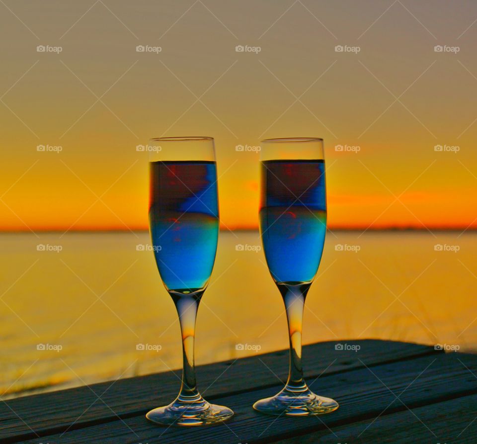 Close-up of blue cocktail glasses in front of sea