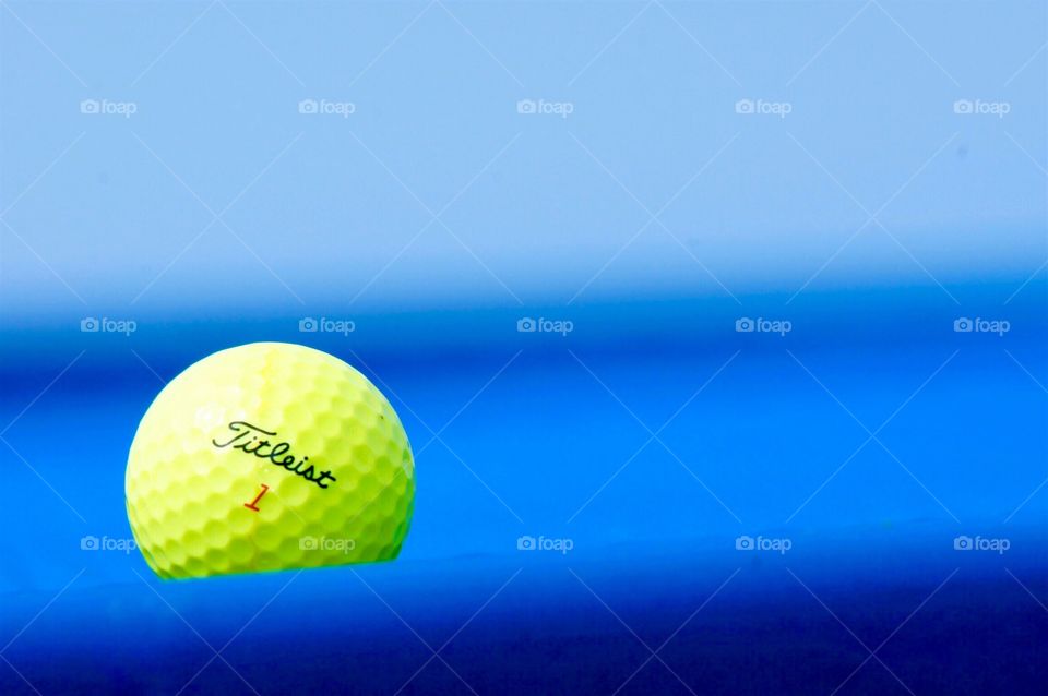 Golf ball against blue background 