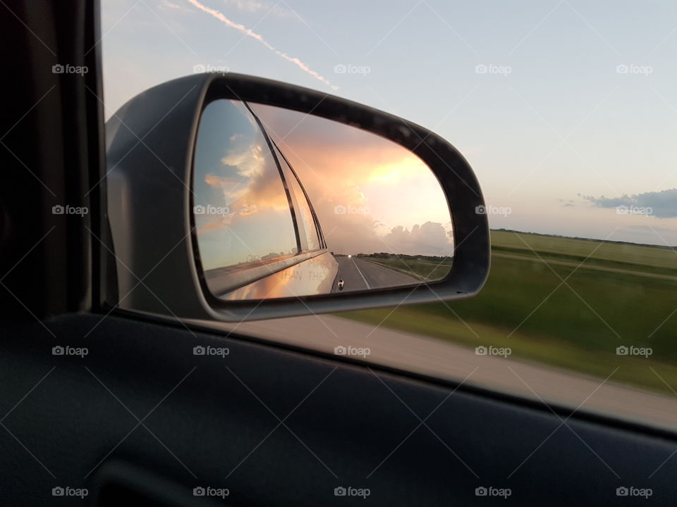 Clouds begin to form as seen from the side mirror