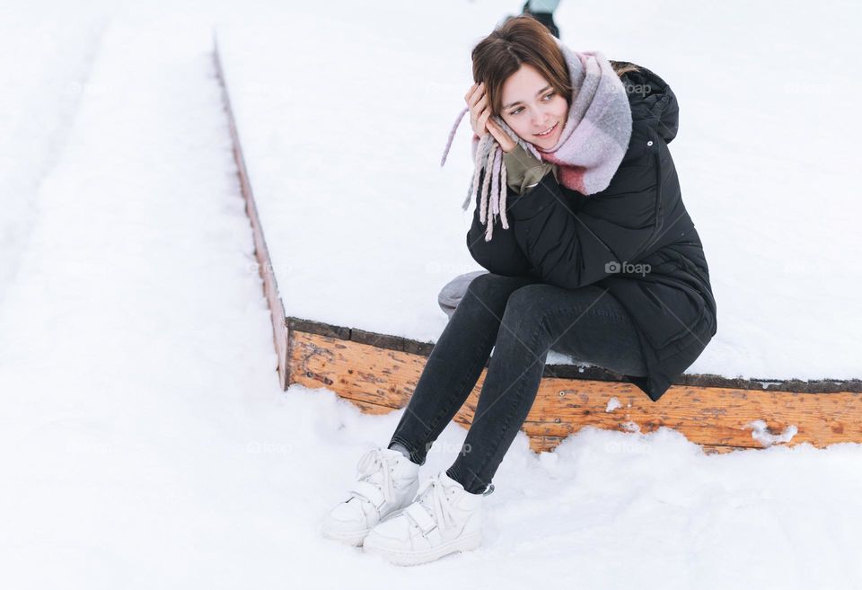 Young woman with mobile phone in white Dr. Martens boots in winter 