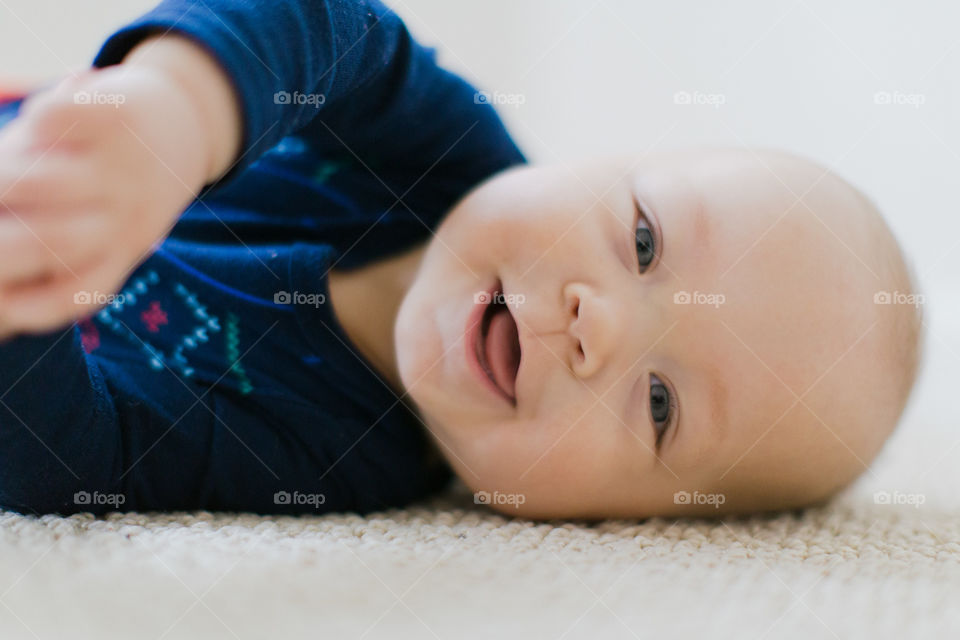 Baby boy smiling while laying down 