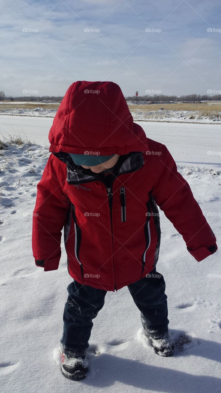 boy in red coat, in the snow