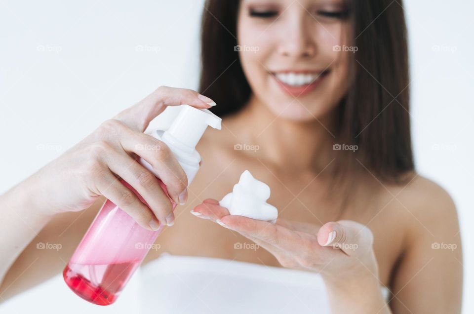 Young woman with cosmetic foam for washing in hands 