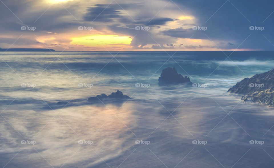 Sunset on the Nazaré coast. Long exposure shows the waves lapping the beach as the sun goes down on an autumn day