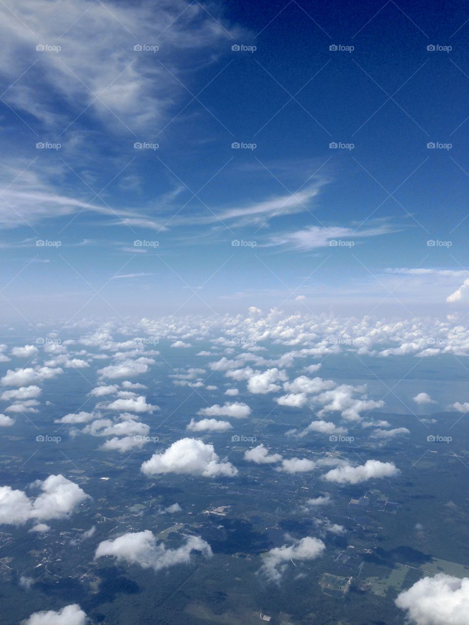 Puffy white  clouds and blue sky in aerial photo taken from jet plane 