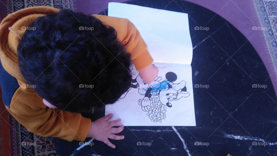 A child colors pictures.