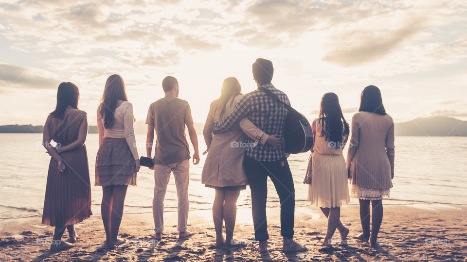 Rear view of friend's group standing in front of beach