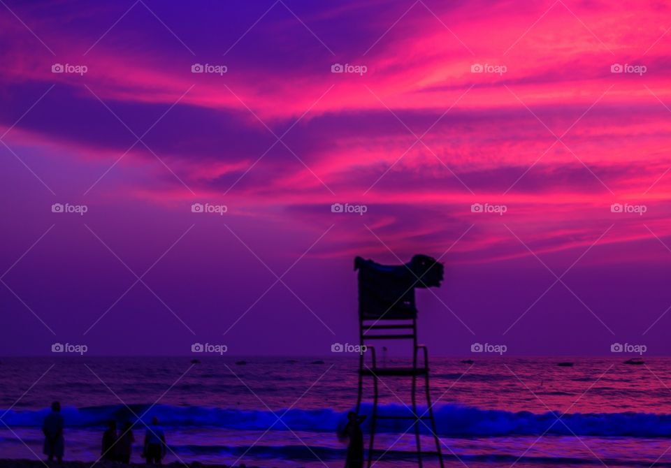 people enjoying mesmerizing sunset colors on the beach