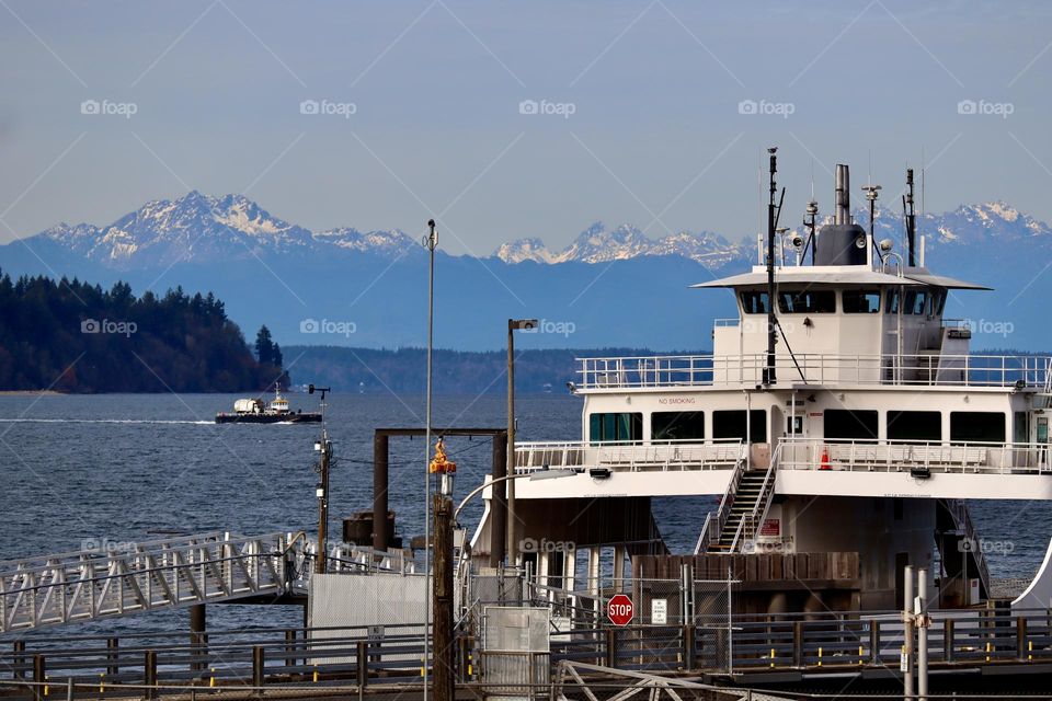 The ferry docks in Steilacoom, Washington while it waits for the next group of commuters to board, Olympic Mountain Range in the distance