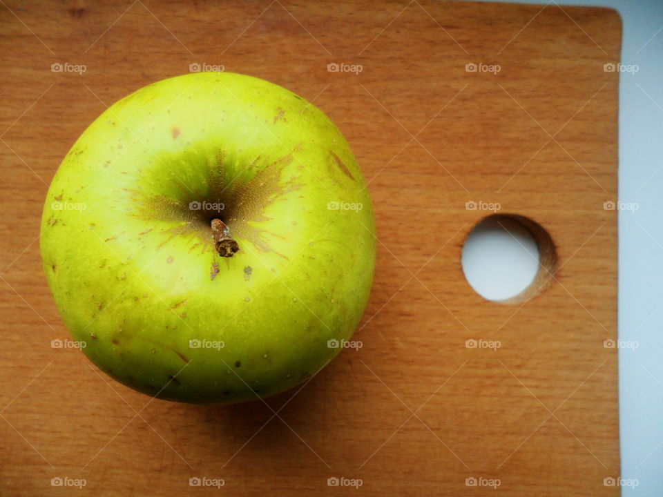 Green apple on a cutting board