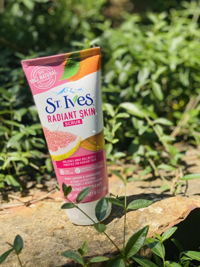 St. Ives Radiant Skin Scrub beauty product with green leaves in nature sunny