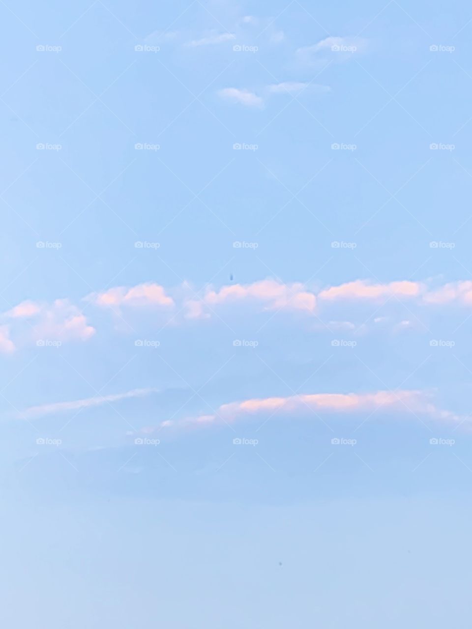 Blue skies and pink clouds - fluffy white clouds in the blue sky 