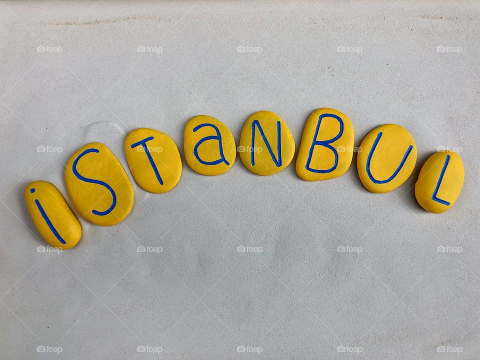 Istanbul, souvenir witha composition of carved and yellow painted stones over white sand