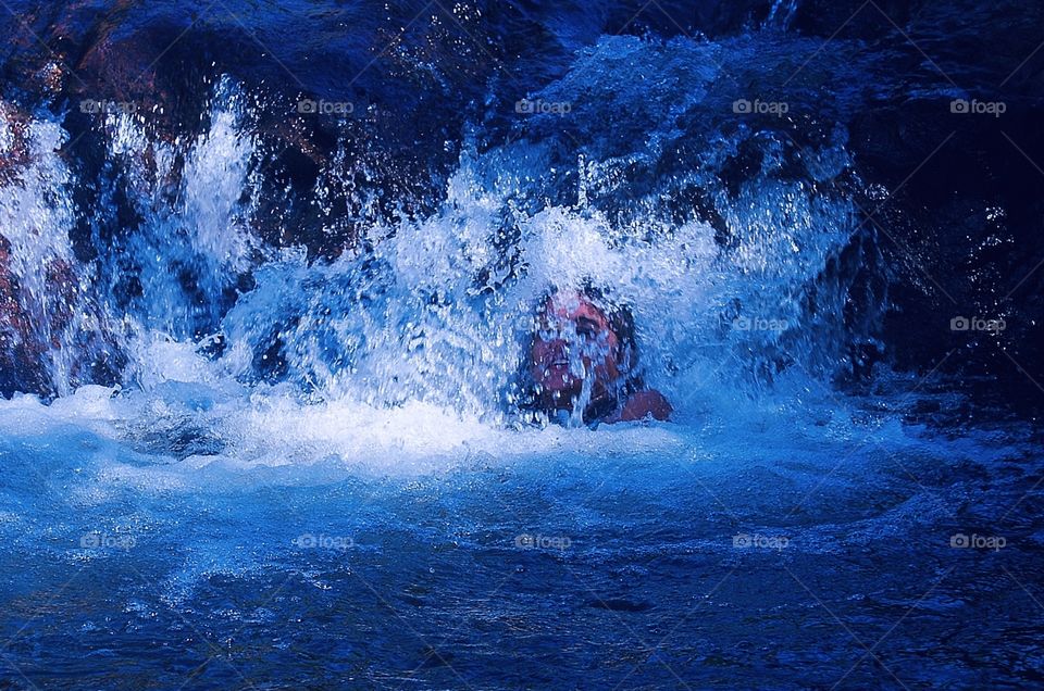 a person bathing in a waterfall