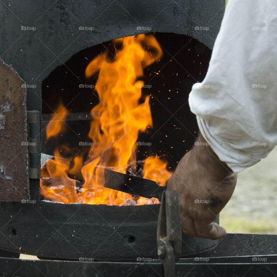 Blacksmith forging metal in a flame