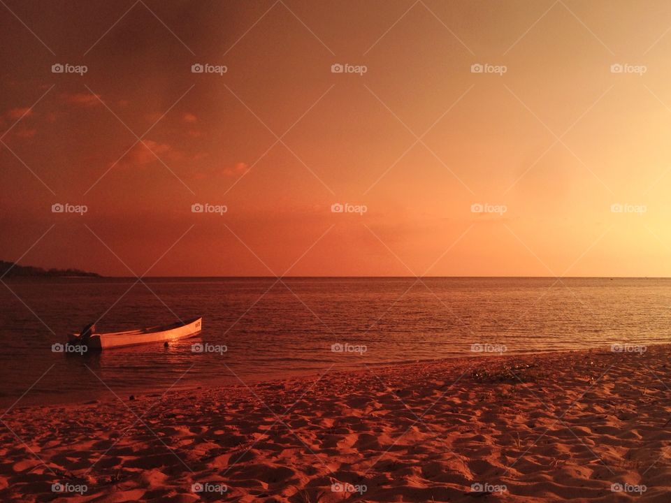 Boat moored in sea against dramatic sky