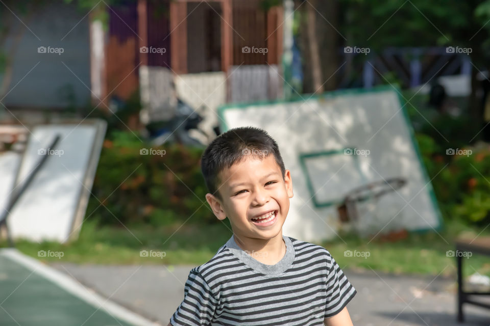 Portrait of a boy Asia, laughing and smiling happily in the park.