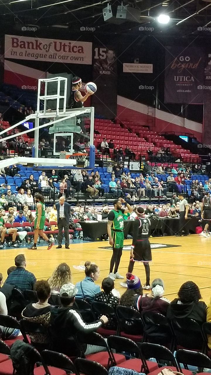 Man Atop Basketball Hoop