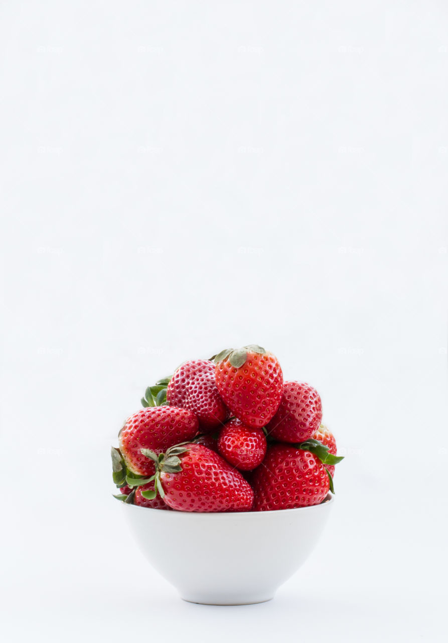 A bowlful of strawberries on an isolated white background. Fresh, ripe strawberries.