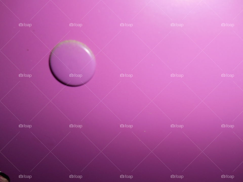 Close-up of paint drop on purple background