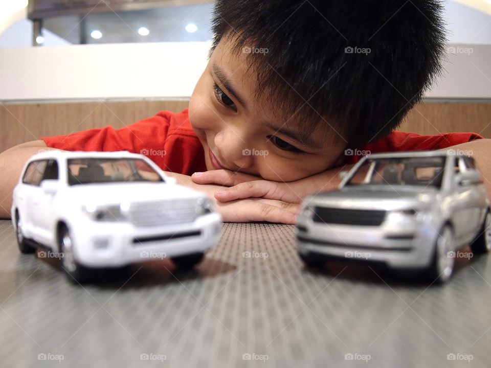 young boy playing with toy cars