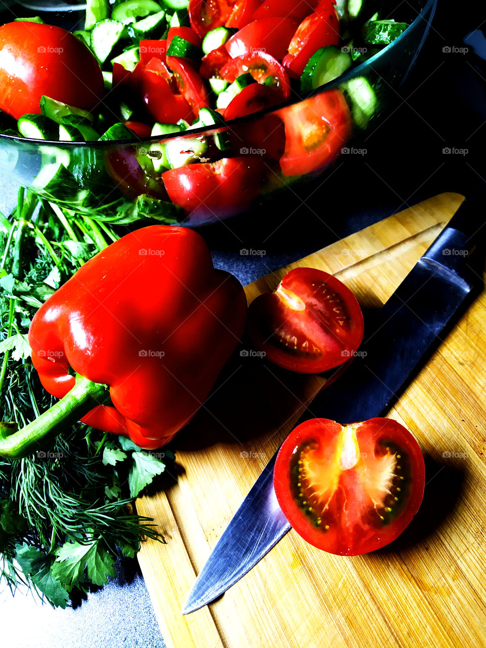 Vegetable Salad: Tomatoes, Cucumbers, Bulgarian Pepper, Greens on a cutting board