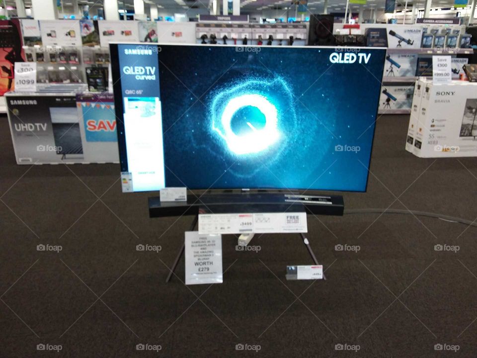 Samsung QLED television with soundbar mounted on studio stand 4K UHD TV