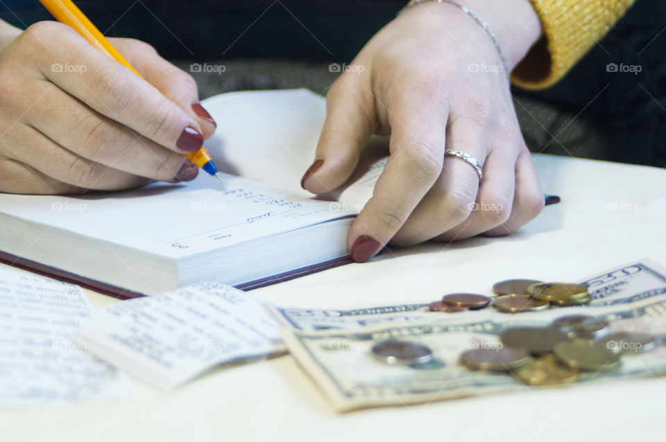 Girl makes notes in a notebook, keeps a record of finances