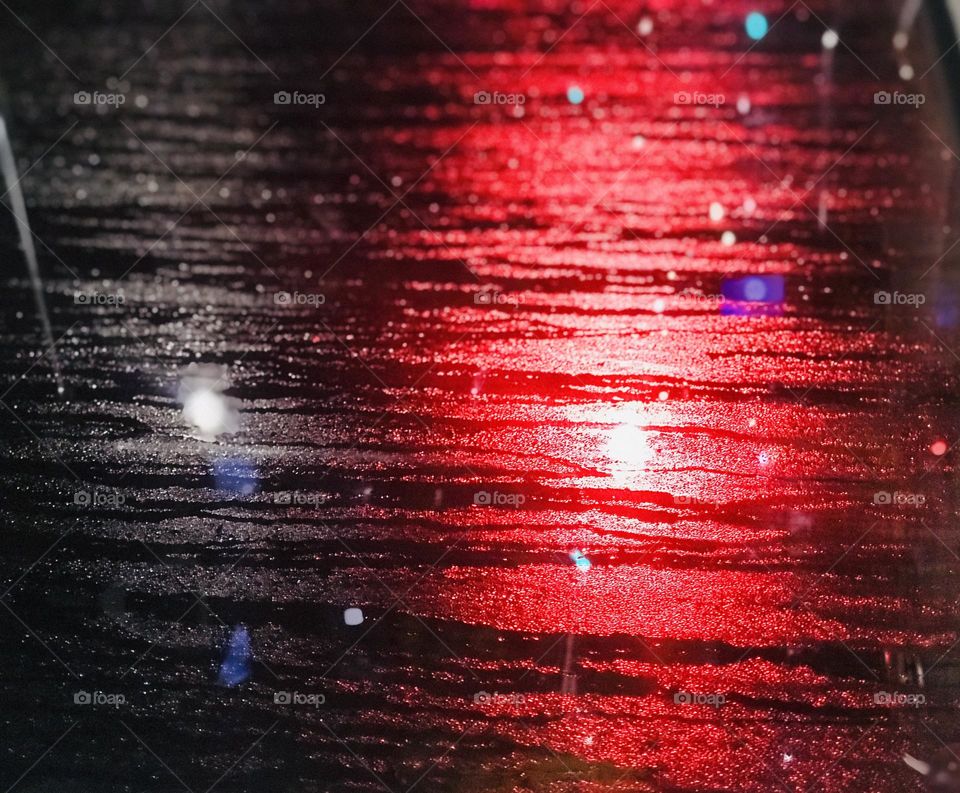 It looks like exactly a rainy day road at the street but it’s exactly picture of a rainy water fell on the mirror outside the bus. signal lights reflection on bus mirror and it’s a click from inside the bus 🚌