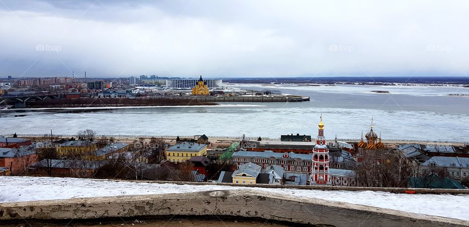 Early spring and ice on the river in the city. two sides of one city