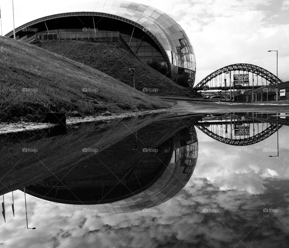 The Sage Gateshead … unusual shaped architecture snapped as a reflection in puddle photography B&W