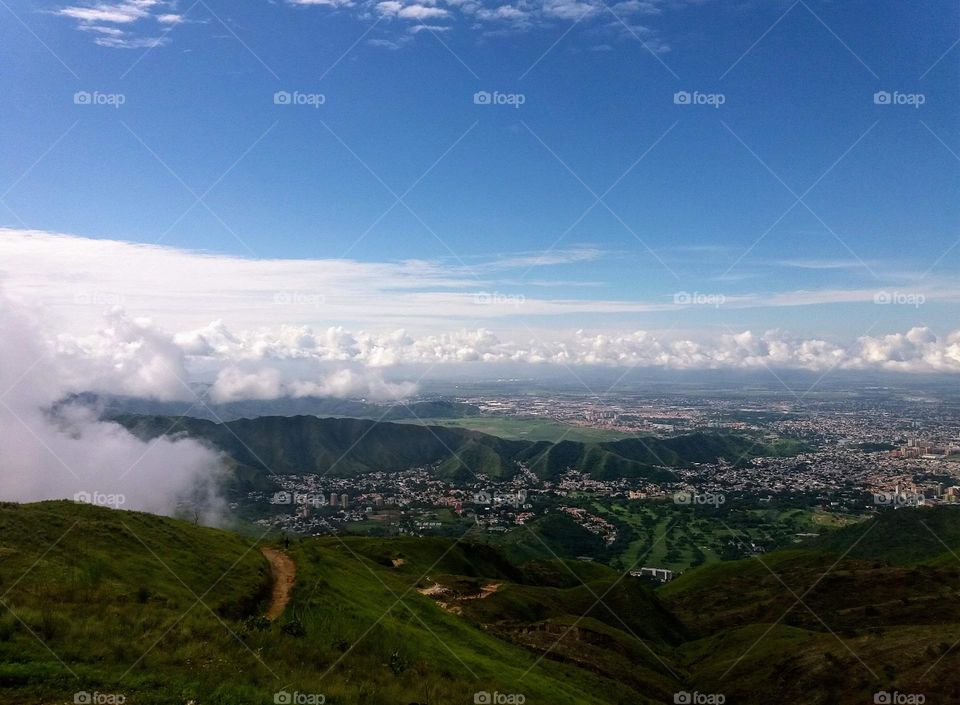 white clouds like tide, blue sky and beautiful landscape where you can see the city