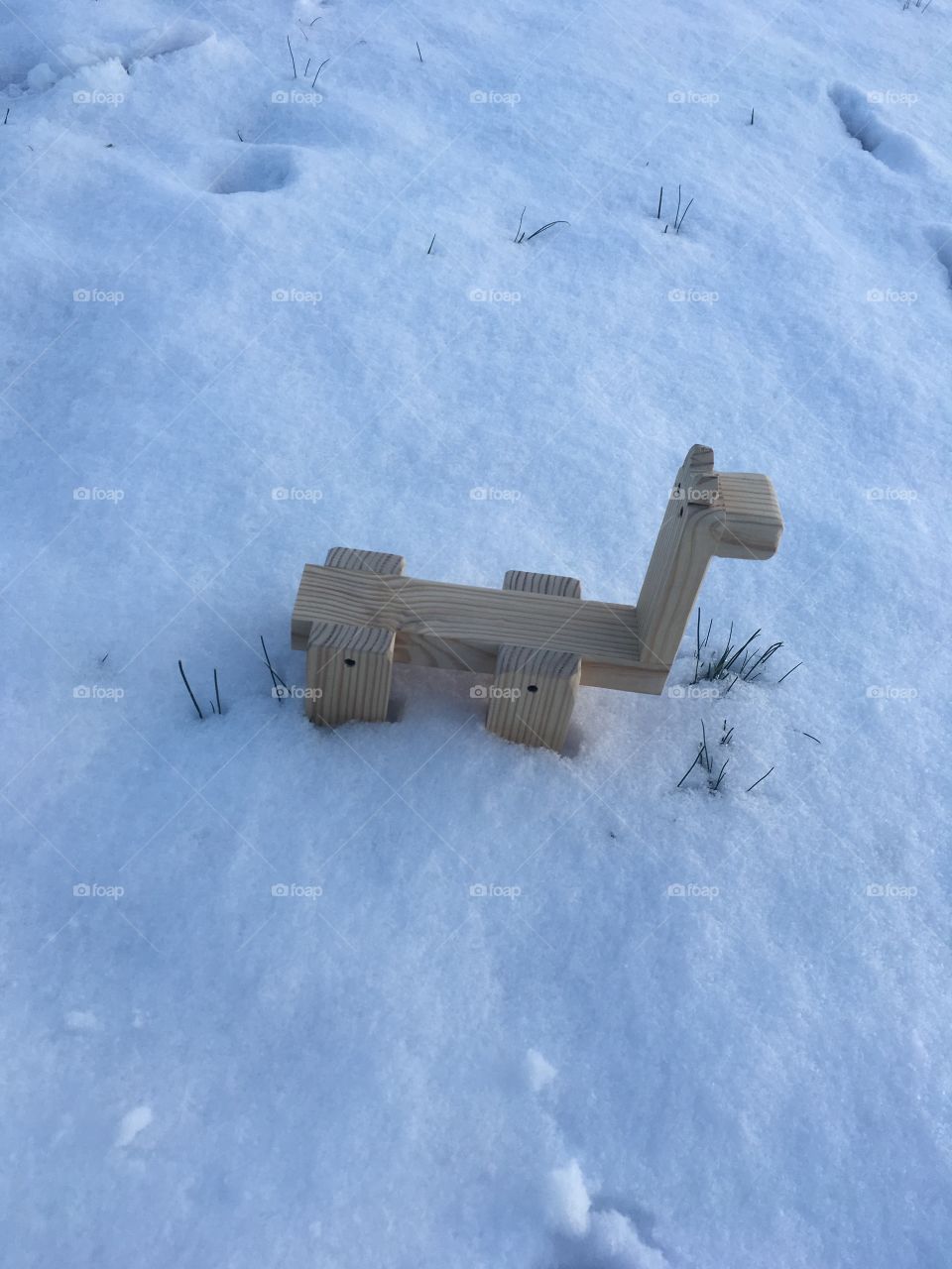 Wooden creature playing in the beautiful, clean snow