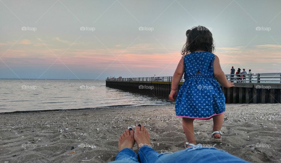 Rear view of girl on beach at sunset