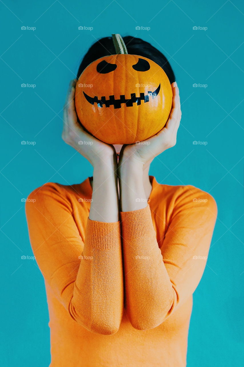 A girl holding pumpkin in her hand