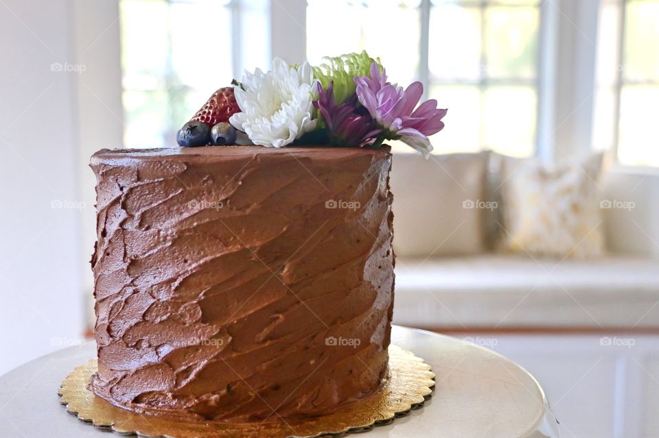 Chocolate cake with flowers and fruits